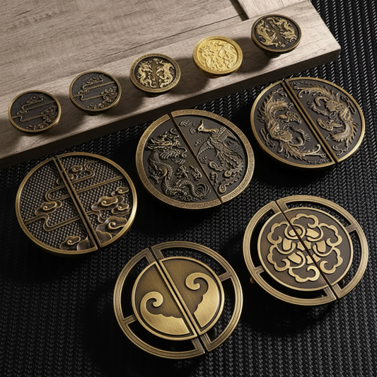 A set of round decorative metal coin-like pieces with split halves, shown in gold and dark metallic finishes on a dark textured surface with a wooden board.