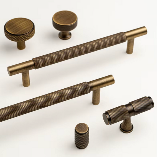 A set of antique bronze cabinet hardware, including two round knobs, two horizontal bar pulls with knurled grips, and two cylindrical pulls, displayed on a clean white background.