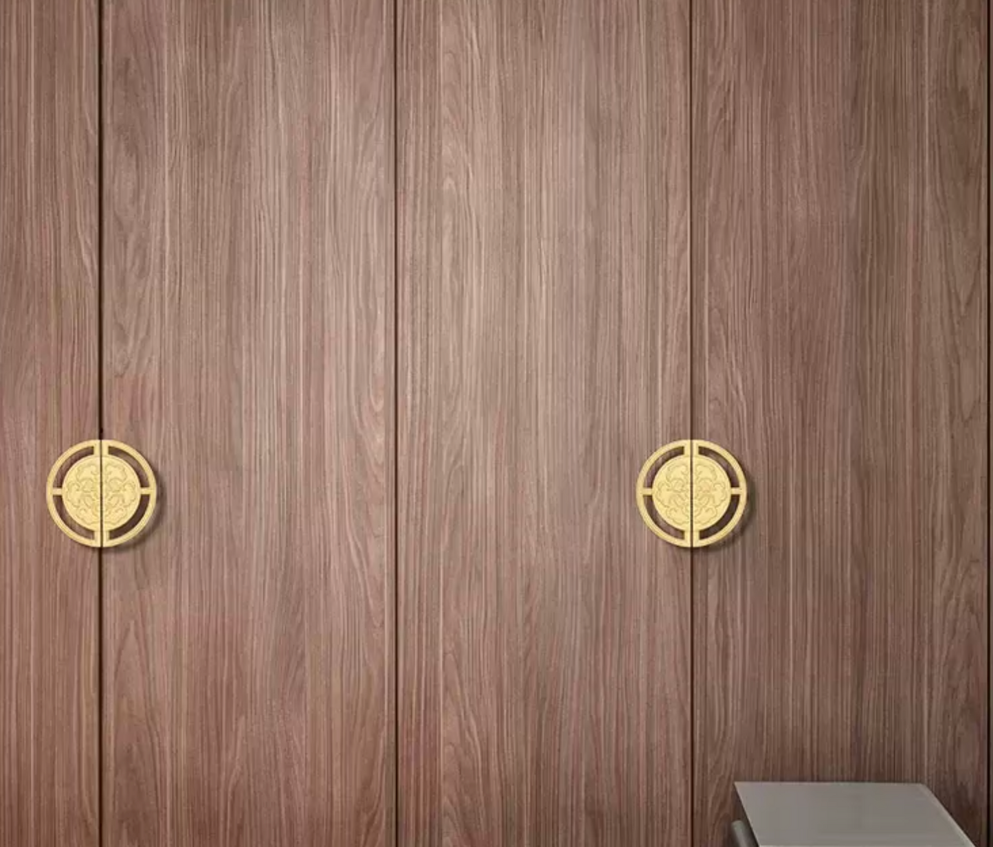 Wood grain cabinet doors with two round gold metal handles, shown in a close-up interior view.