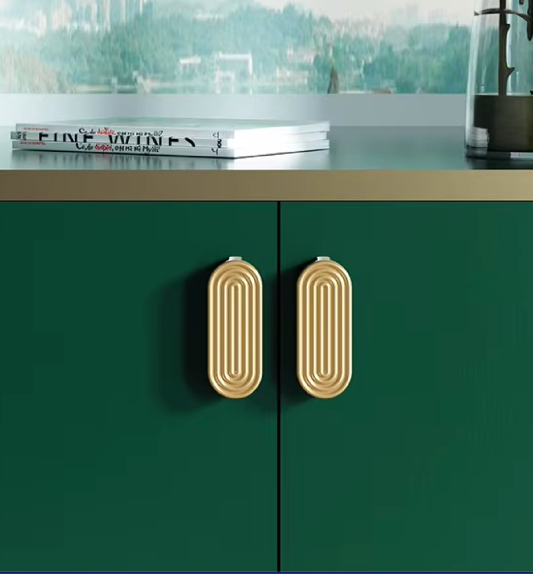 Dark green cabinet doors with two ribbed gold oval handles, shown in a kitchen setting with a countertop and blurred background.