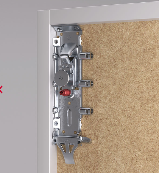 Close-up of a silver metal door lockset and latch mechanism mounted on a white door frame next to a textured beige wall.
